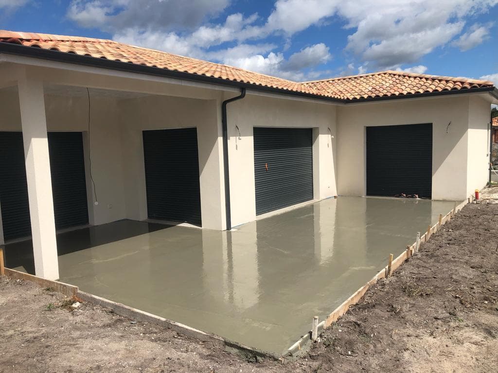 Dalle béton fraîchement coulée devant une maison neuve