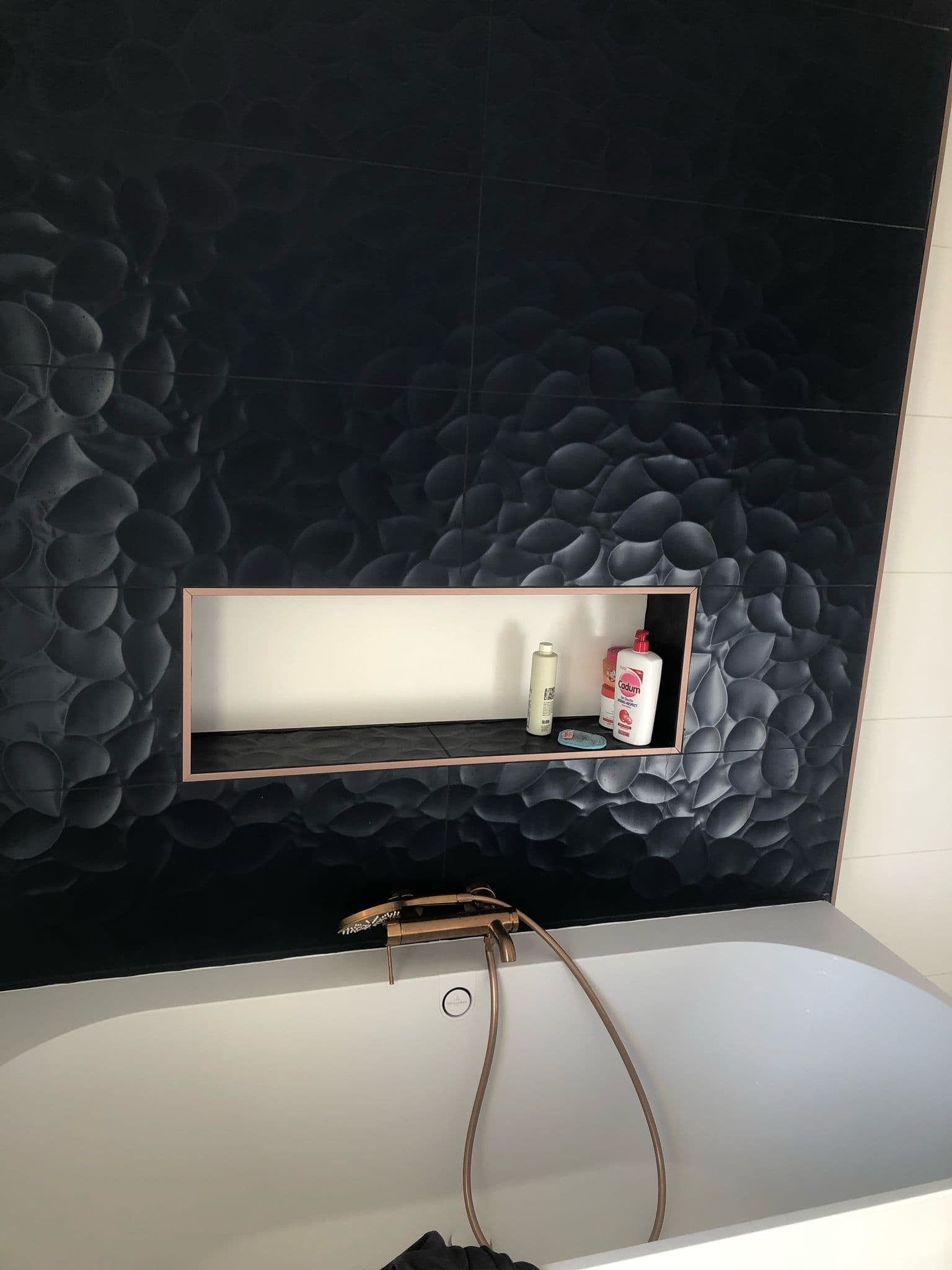 Salle de bain avec carrelage noir en relief et niche bois